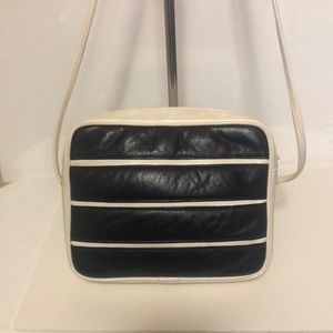 L.J. Simone black and cream colored leather handbag with long straps.